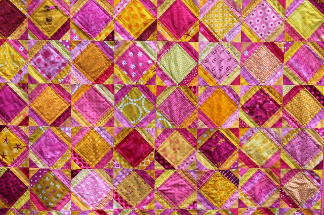 Bright easy kids quilt made with pink and yellow fabric.
